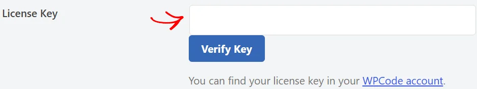 An arrow pointing at the empty License Key field on the WPCode network settings page